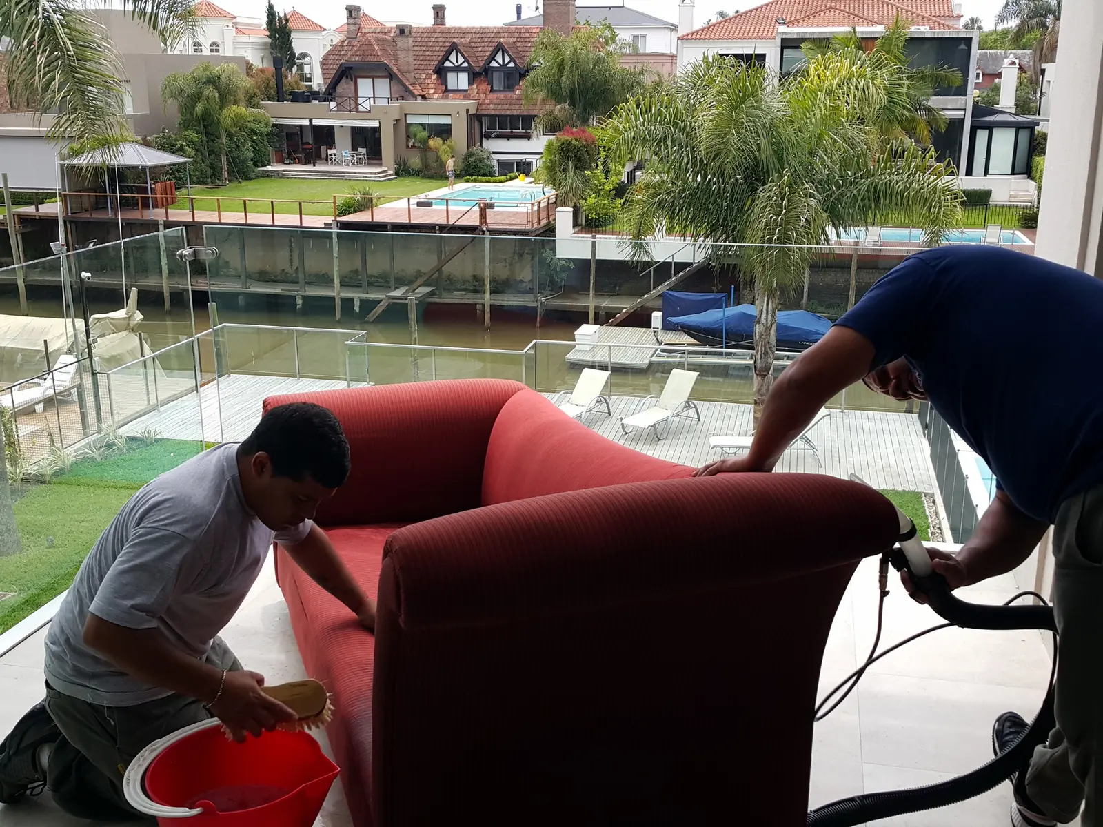 Dos operarios de Carpet Clean lavando un sillón a domicilio