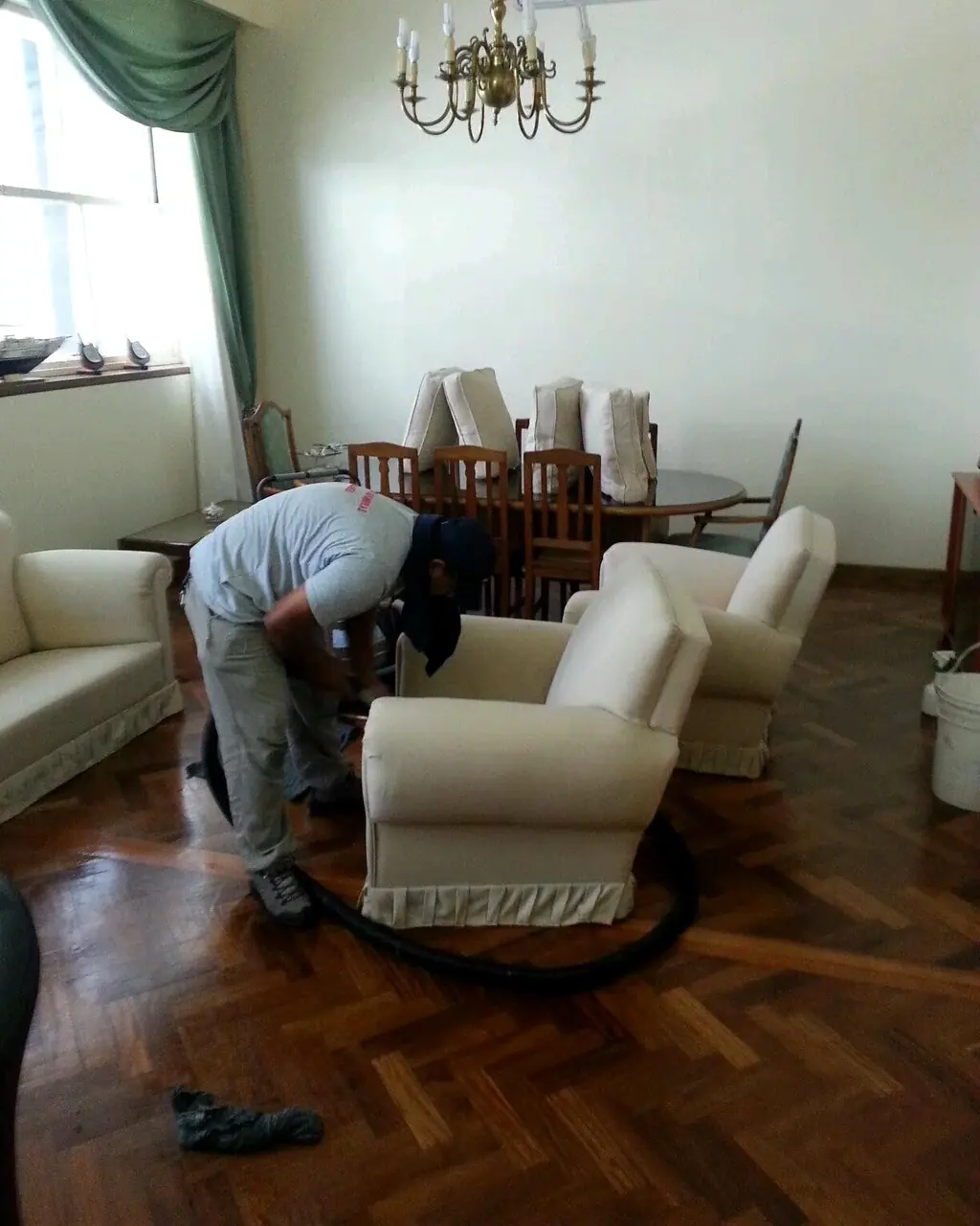 Operario de Carpet Clean lavando sillones en un living