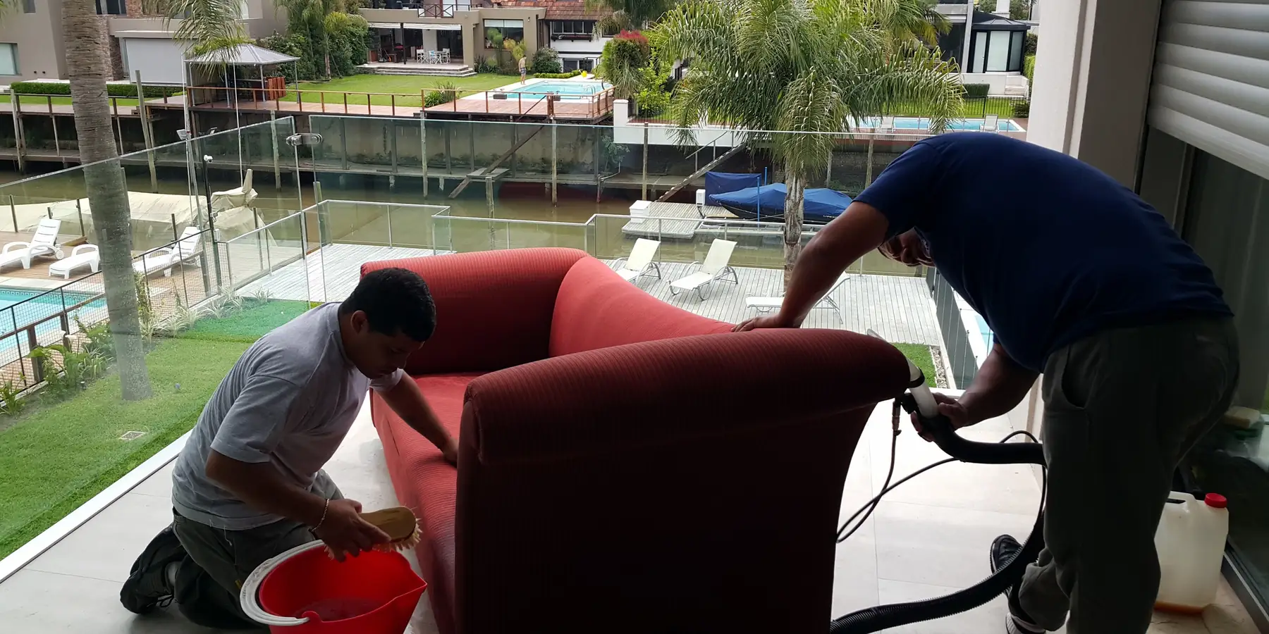 Dos operarios de Carpet Clean lavando un sillón a domicilio